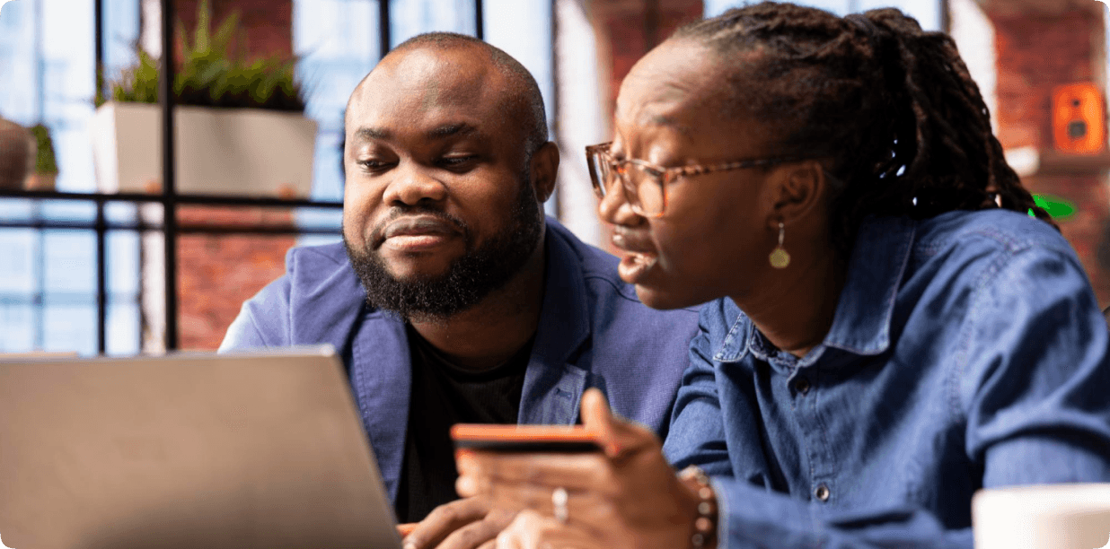 Two people reviewing a card payment together on a laptop